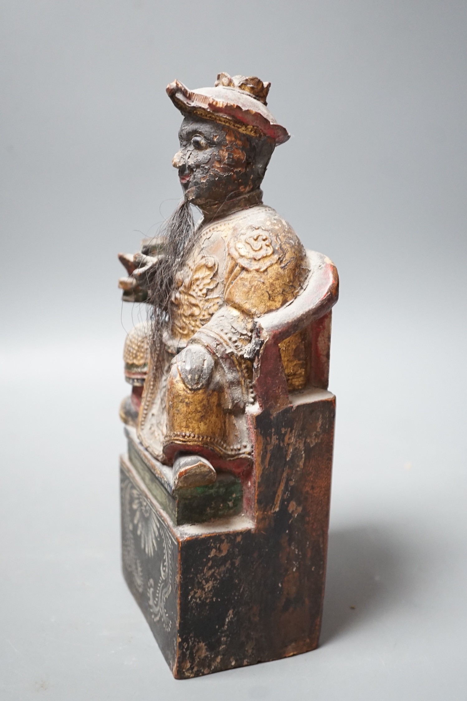 A 19th century Chinese painted wood figure with ink inscription verso, 24.5cms high